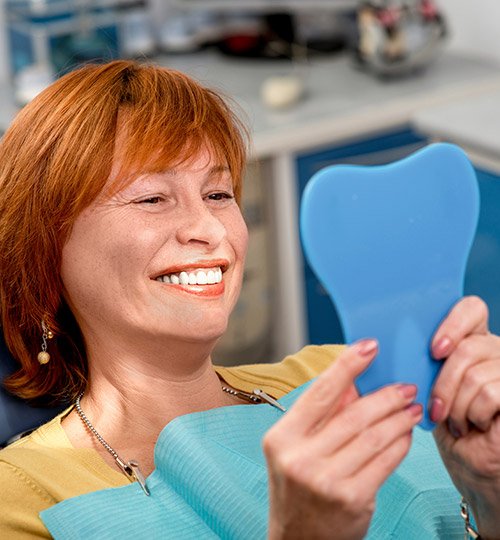 Senior woman examining her restored smiled