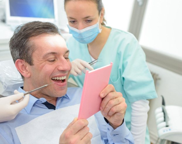 A man admiring his dental bridge from downtown Boston