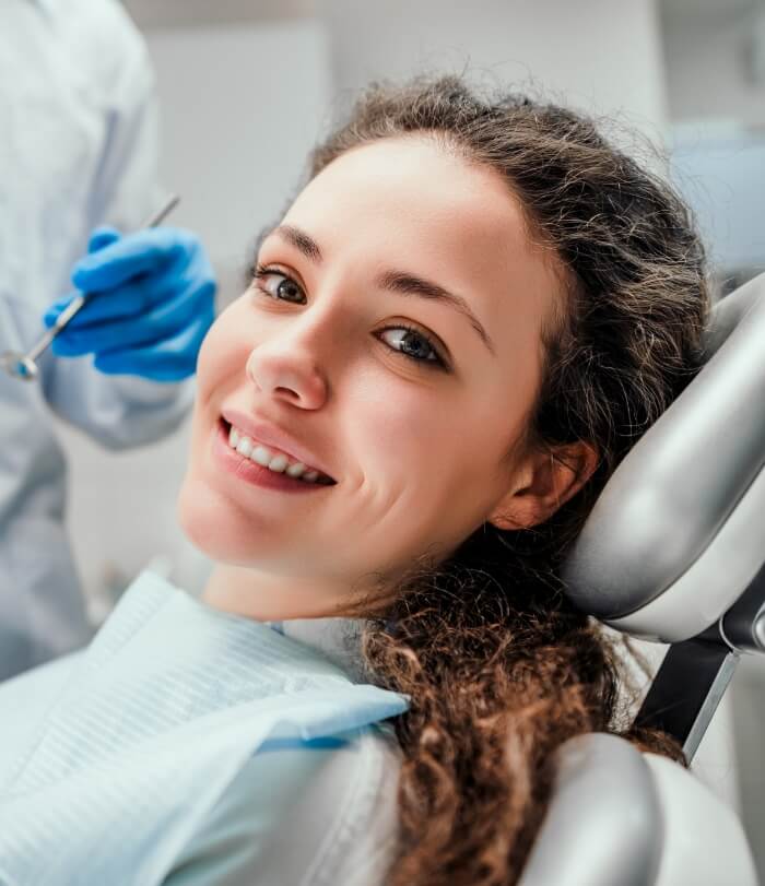 Woman in dental chair smiling during preventive dentistry visit