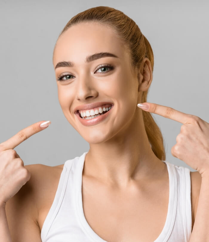 Woman pointing to smile after cosmetic dentistry