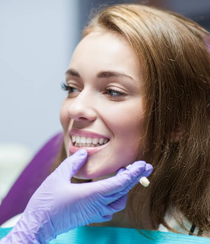 Dentist examining smile after dental crown and fixed bridge treatment