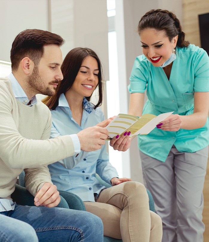 Dental team member and patients discussing Delta Dental insurance coverage