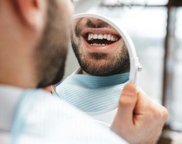 a patient smiling in a mirror 