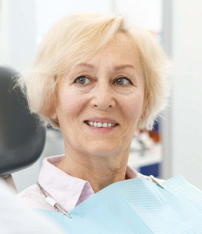 Woman with healthy smile thanks to dental implant retained dentures