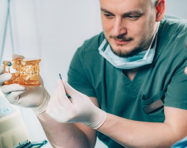 Dental team member explaining how dental implant supported dentures work