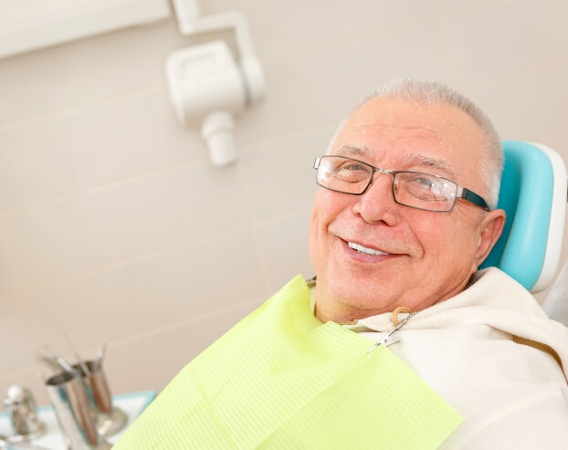 Man smiling after dental implant denture treatment