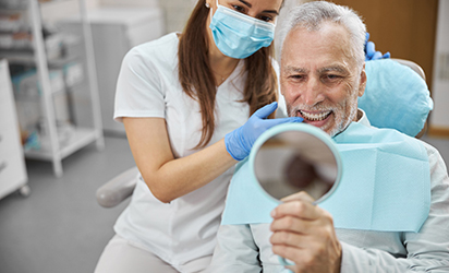 An elderly man happy with his new dental implant