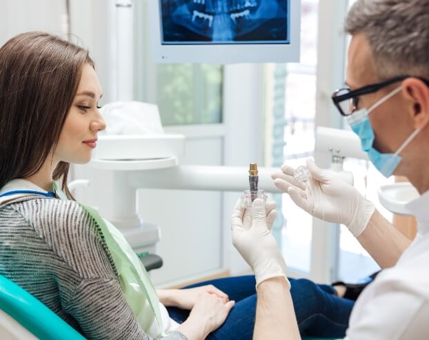 Dentist and patient discussing the four step dental implant process