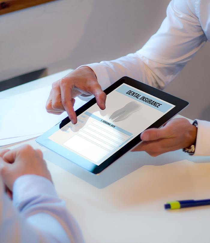 Dentist and patient reviewing forms for dental insurance in Boston