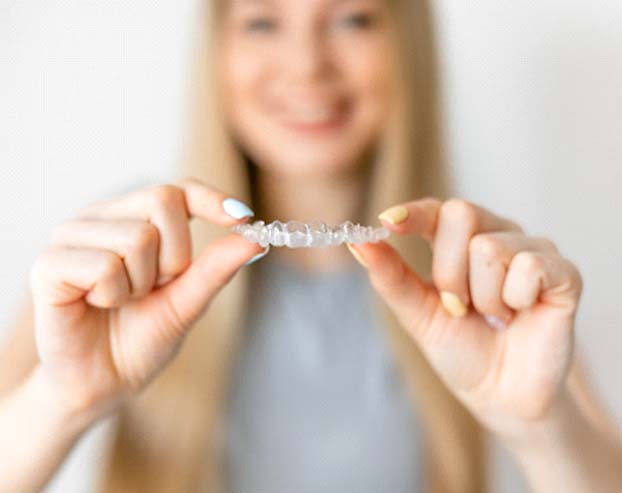 Patient holding Invisalign in Boston