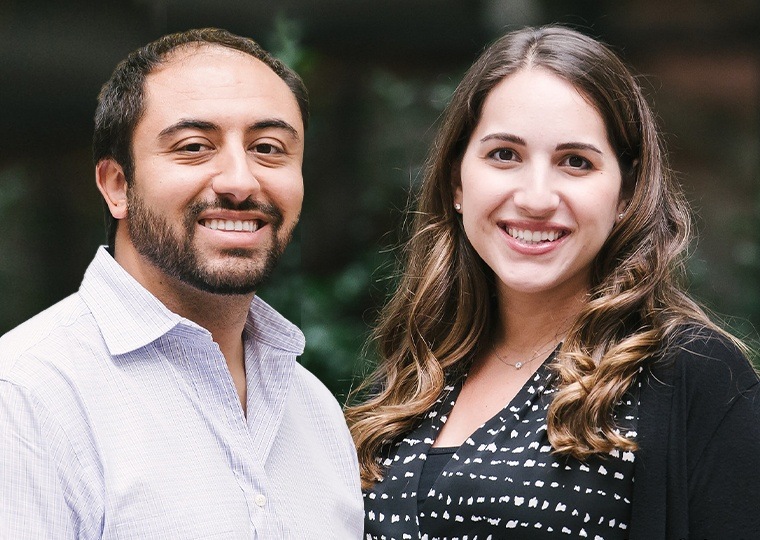 Three dentists smiling in front of building