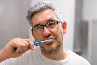 Man brushing his teeth to prevent dental emergencies in Boston 