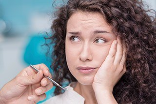 Woman in pain holding her cheek