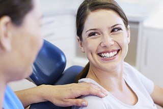 Relaxed woman laughing in dental chair