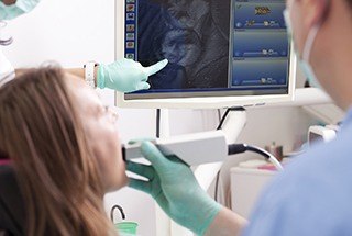 Woman and dentist looking at tooth photos