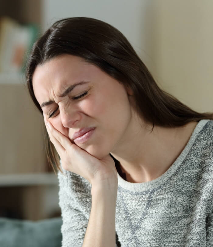 Woman holding jaw in pain before T M J therapy