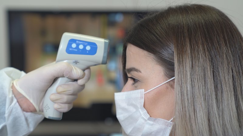 Woman having her temperature taken